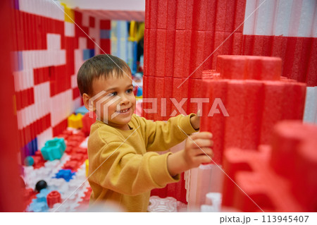 Boy child playing with huge building blocks in entertainment center 113945407