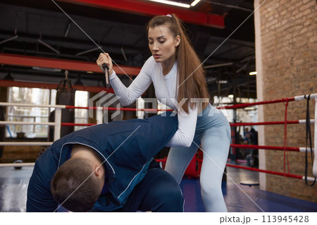 Woman exercising with martial arts trainer practicing self-defense from knife Woman exercising with martial arts trainer practicing self-defense from knife 113945428