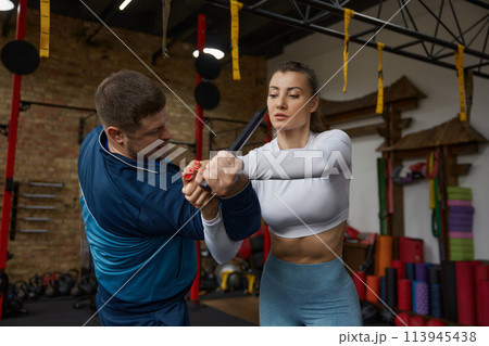 Young sportive woman exercising with knife weapon with trainer Young sportive woman exercising with knife weapon with trainer 113945438