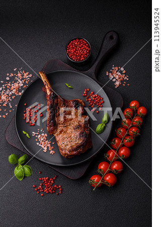 Delicious juicy beef steak on the bone, tomahawk with salt, spices and herbs 113945524