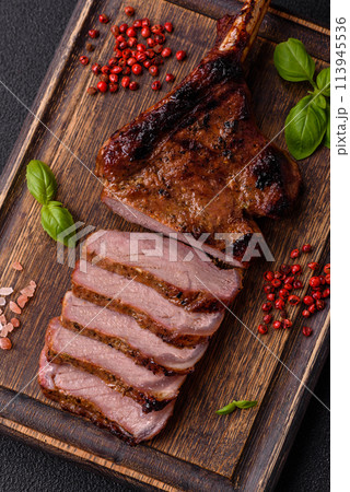 Delicious juicy beef steak on the bone, tomahawk with salt, spices and herbs 113945536