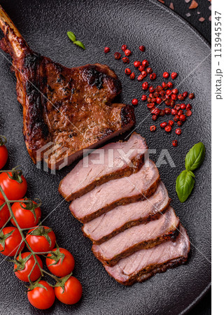 Delicious juicy beef steak on the bone, tomahawk with salt, spices and herbs 113945547