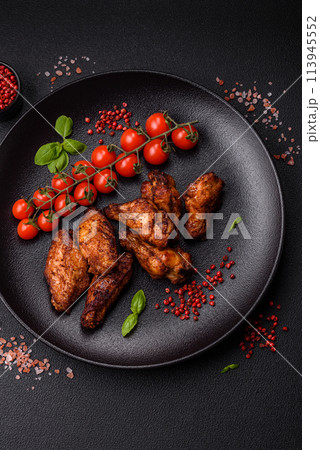 Delicious juicy chicken wings baked on the grill with salt, spices and herbs Delicious juicy chicken wings baked on the grill with salt, spices and herbs 113945552