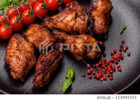 Delicious juicy chicken wings baked on the grill with salt, spices and herbs Delicious juicy chicken wings baked on the grill with salt, spices and herbs 113945553
