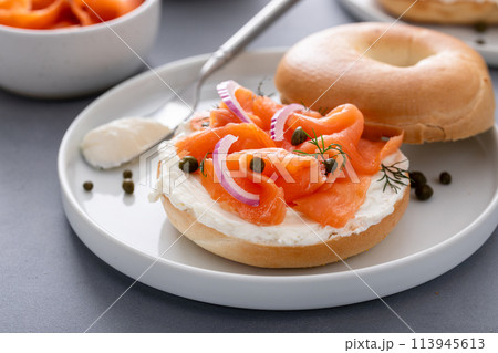Plain bagel with salmon and cream cheese with fresh dill and capers Plain bagel with salmon and cream cheese with fresh dill and capers 113945613