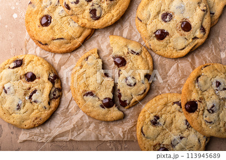 Chocolate chip cookies with flaky salt on parchment paper 113945689
