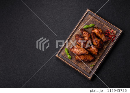 Delicious juicy chicken wings baked on the grill with salt, spices and herbs 113945726