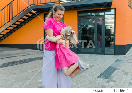 Blonde little girl with cochlear implant playing with her mother outdoor. Hear impairment deaf and health concept. Disability and inclusion. Copy space 113946664