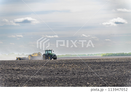A tractor sows a field with grain. A tractor sows a field with grain. 113947052