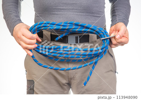 coil of climbing rope in the hands of a tourist. 113948090