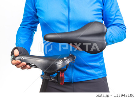 cyclist inspects, compares and selects a saddle for a bicycle. 113948106