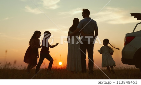 Family at sunset near car silhouettes. Kids children with ball running around parents enjoying picnic in nature park. Bringing family closer strengthening relationships outdoor outside activities. Family at sunset near car silhouettes. Kids children with ball running around parents enjoying picnic in nature park. Bringing family closer strengthening relationships outdoor outside activities. 113948453