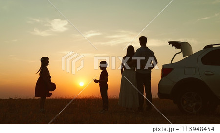 Family at sunset by car in field silhouettes. Children kids plays ball parents hugging enjoying romantic atmosphere happy moment. Importance of Spending Time Together Creating Lasting Family Memories Family at sunset by car in field silhouettes. Children kids plays ball parents hugging enjoying romantic atmosphere happy moment. Importance of Spending Time Together Creating Lasting Family Memories 113948454