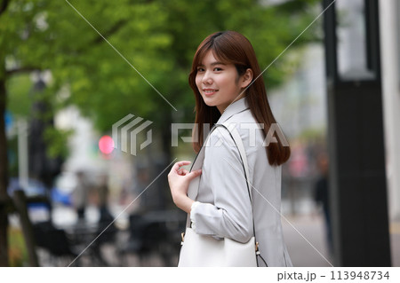 振り向いたビジネス街を歩くビジネスウーマン_4 振り向いたビジネス街を歩くビジネスウーマン_4 113948734