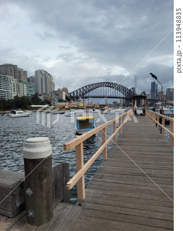 Sydney's harbour foreshore set against the famous Sydney Harbour bridge on a cloudy overcast day 113948835