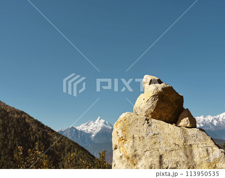huge prayer stone with meili snow mountain in background in china's sichuan province huge prayer stone with meili snow mountain in background in china's sichuan province 113950535
