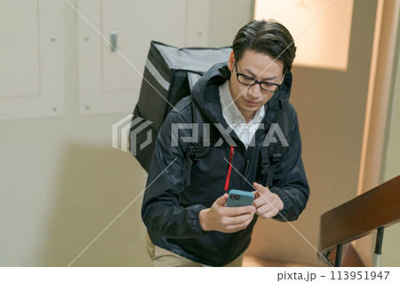 デリバリーバッグを背負った男性 113951947