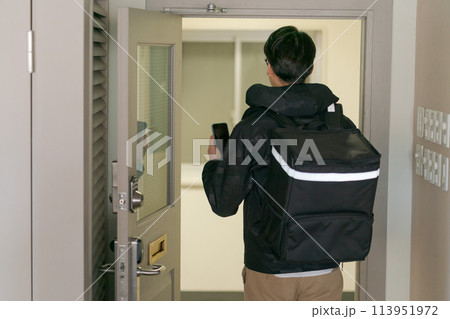 デリバリーバッグを背負った男性の後ろ姿 デリバリーバッグを背負った男性の後ろ姿 113951972