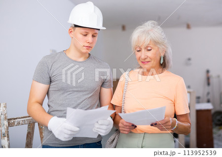 Teenager helping senior woman with home improvement works 113952539