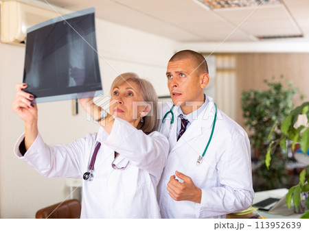 Two doctors examining x-ray of patient and discussing diagnosis Two doctors examining x-ray of patient and discussing diagnosis 113952639