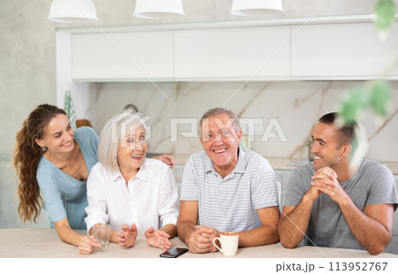 Family of four sits at table and talking 113952767