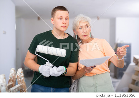 Teenager helping senior woman with home improvement works Teenager helping senior woman with home improvement works 113953050
