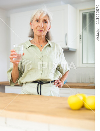 Smiling mature woman with glass of water 113953070