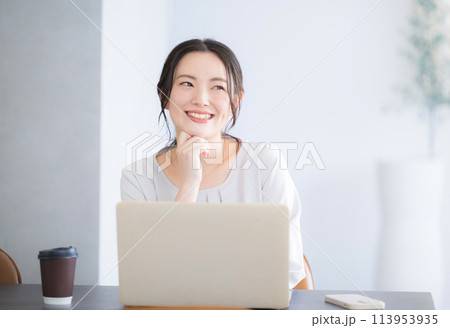 パソコンをしながら考える顎に手を当てるかわいい若い日本人(アジア人）女性 113953935