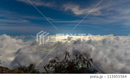 Night at the top of the Agung volcano. Panoramic view of East Java and Bali against the background of clouds. The background of the natural landscape. Bali Island, Indonesia 113955564