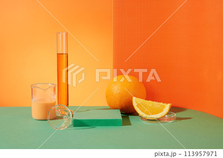Lab theme on fresh orange background with laboratory equipment, an orange, a part of orange and empty green podium in the middle. Advertising photo with copy space Lab theme on fresh orange background with laboratory equipment, an orange, a part of orange and empty green podium in the middle. Advertising photo with copy space 113957971