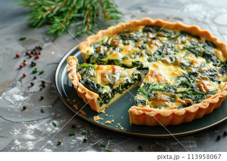 Savory tart of rich egg custard, spinach and cheese with cut out a slice on the plate Savory tart of rich egg custard, spinach and cheese with cut out a slice on the plate 113958067