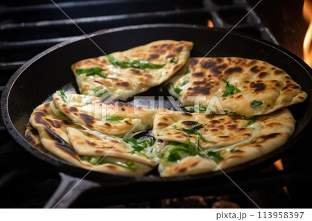 Frying flatbread filled with fresh herbs and cheese. Khychiny or qutab. 113958397