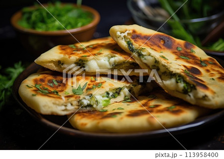 Frying flatbread filled with fresh herbs and cheese. Khychiny or qutab. 113958400