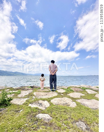 琵琶湖湖岸で景色を眺める父と子 113958659