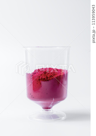 Colorful pink holi powder sand in measuring cup on white background. 113959043