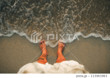 Feet with evening sea waves on the island Feet with evening sea waves on the island 113963963