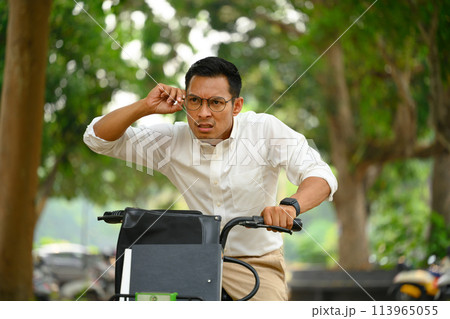 Shot o man office worker riding a bike and hurrying up at work 113965055