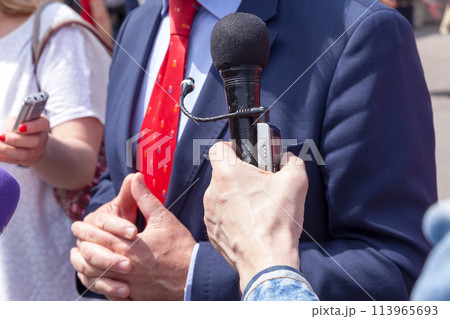 Journalist holding microphone making media interview with businessman Journalist holding microphone making media interview with businessman 113965693