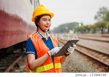 Train locomotive engineer women worker. Young teen Asian working check service maintenance train using tablet computer software. Train locomotive engineer women worker. Young teen Asian working check service maintenance train using tablet computer software. 113966146
