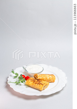 Rustic food - Pancakes with sour cream and cherry tomatoes on a white background. Maslenitsa 113966663