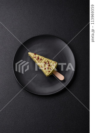 Delicious sweet cheesecake with fruits covered with icing with a wooden stick 113969359