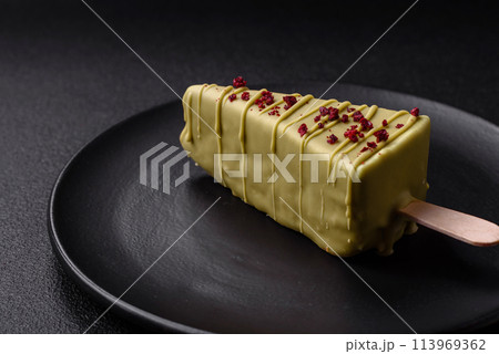 Delicious sweet cheesecake with fruits covered with icing with a wooden stick Delicious sweet cheesecake with fruits covered with icing with a wooden stick 113969362