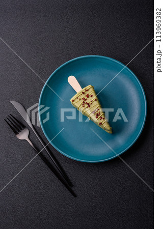 Delicious sweet cheesecake with fruits covered with icing with a wooden stick 113969382