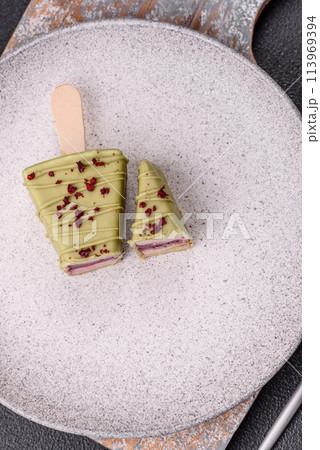 Delicious sweet cheesecake with fruits covered with icing with a wooden stick Delicious sweet cheesecake with fruits covered with icing with a wooden stick 113969394