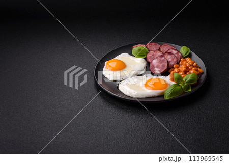 English breakfast with fried eggs, bacon, beans, tomatoes, spices and herbs 113969545