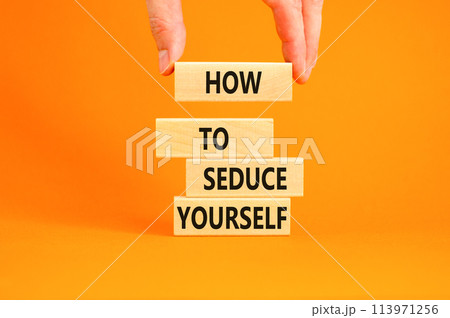 How to seduce yourself symbol. Concept word How to seduce yourself on wooden blocks. Businessman hand. Beautiful orange table orange background. Business and how to seduce yourself concept. Copy space 113971256