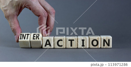 Action or interaction symbol. Businessman turns wooden cubes and changes the word action to interaction. Beautiful grey background, copy space. Business and action or interaction concept. 113971286
