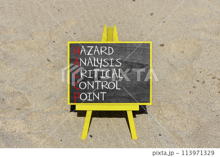 HACCP symbol. Concept words HACCP hazard analysis critical control point on beautiful blackboard. Beautiful sand background. Business HACCP hazard analysis critical control point concept. Copy space. 113971329