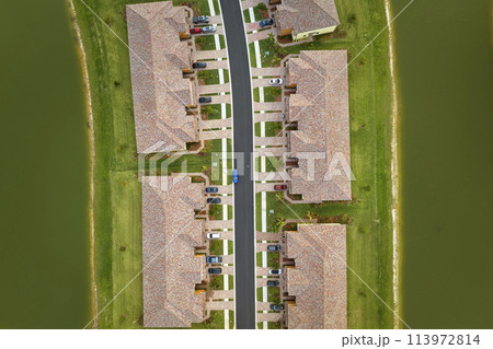 View from above of densely built residential houses in closed living clubs in south Florida. American dream homes as example of real estate development in US suburbs View from above of densely built residential houses in closed living clubs in south Florida. American dream homes as example of real estate development in US suburbs 113972814