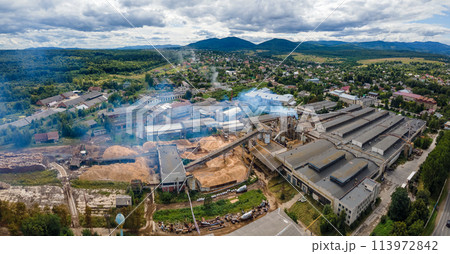Aerial view of wood processing plant with smokestack from production process polluting environment at factory manufacturing yard 113972842